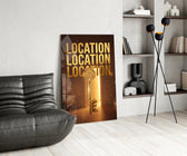 gold real estate key with a skyline glass wall art leaning beside a dark leather sofa