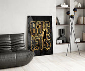 gold basketball typography with a jump-shot silhouette glass wall art leaning beside a dark leather sofa