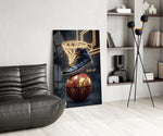 a high-top sneaker over a golden globe basketball glass wall art leaning beside a dark leather sofa