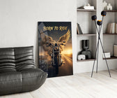 born to ride winged motorcycle glass wall art leaning beside a dark leather sofa