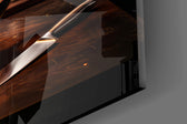 Close-up detail of the phoenix of flame rising from the burning skillet on the glass surface