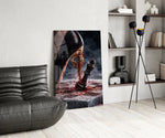 stiletto heel crushing a chess king glass wall art leaning beside a dark leather sofa