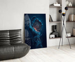 liquid water hand holding an ornate compass glass wall art leaning beside a dark leather sofa