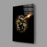 golden pistol wrapped by a black serpent glass wall art angled to show the polished tempered glass panel