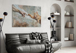 ginger kitten reaching a paw to a human hand glass wall art styled above an armchair in a reading corner