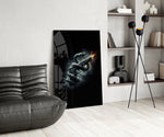 a serpent coiled around a firing pistol glass wall art leaning beside a dark leather sofa