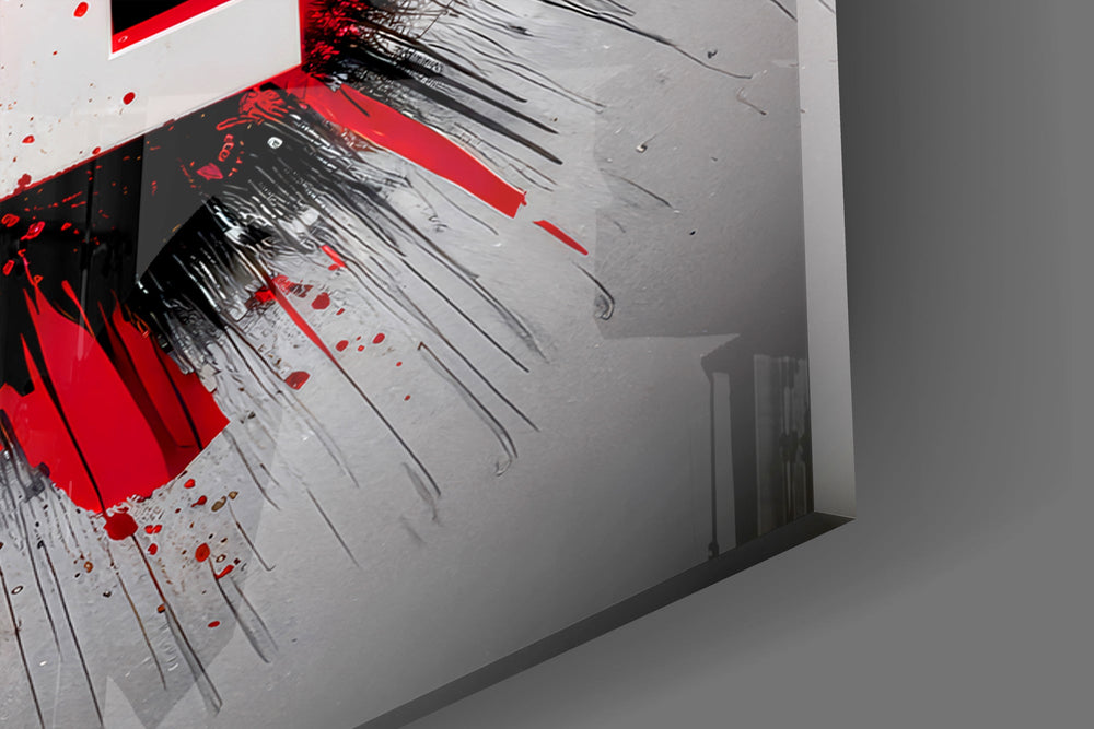 Close-up detail of the white block letters against red and black paint on the glass surface