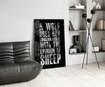 wolf opinion of sheep quote glass wall art leaning beside a dark leather sofa