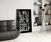 wolf opinion of sheep quote glass wall art leaning beside a dark leather sofa