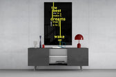 wake up dreams quote in yellow glass wall art displayed above a console in a designer interior