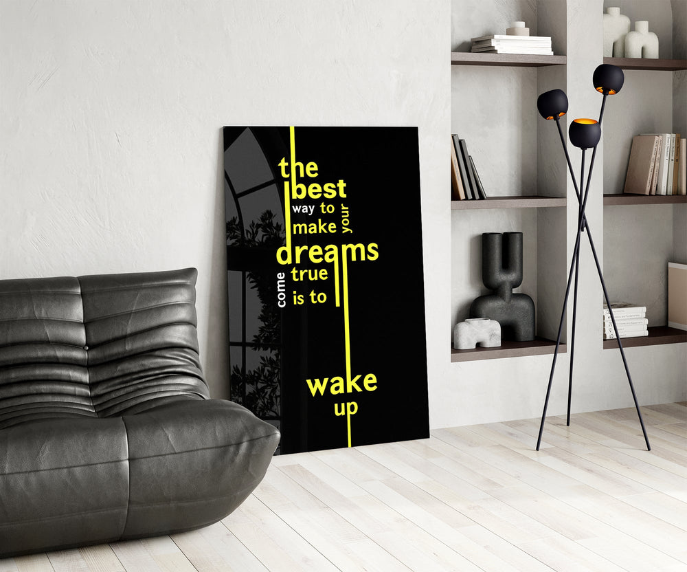 wake up dreams quote in yellow glass wall art leaning beside a dark leather sofa