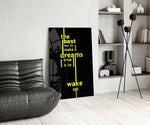 wake up dreams quote in yellow glass wall art leaning beside a dark leather sofa