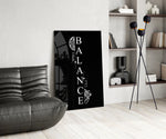 balance brain and heart quote glass wall art leaning beside a dark leather sofa