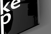 Close-up detail of the white type interlocked along thin vertical lines on the glass surface