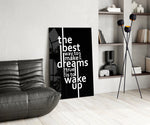 wake up dreams quote in black and white glass wall art leaning beside a dark leather sofa