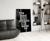 wake up dreams quote in black and white glass wall art leaning beside a dark leather sofa