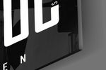 Close-up detail of the towering condensed capitals and the hidden hustle mottos woven through them on the glass surface