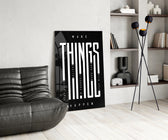 make things happen typography glass wall art leaning beside a dark leather sofa