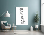 balance brain and heart typography glass wall art styled above an armchair in a reading corner