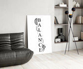 balance brain and heart typography glass wall art leaning beside a dark leather sofa