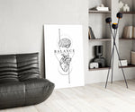 brain above heart balance line art glass wall art leaning beside a dark leather sofa