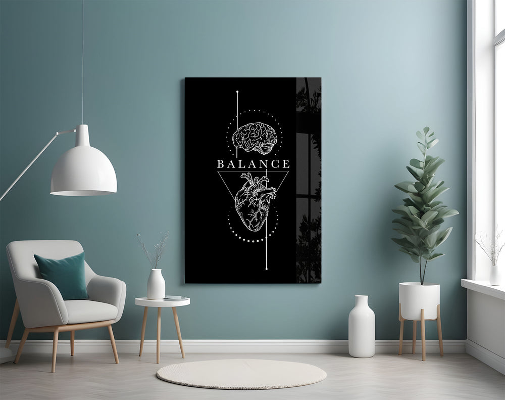 brain above heart balance on black glass wall art styled above an armchair in a reading corner