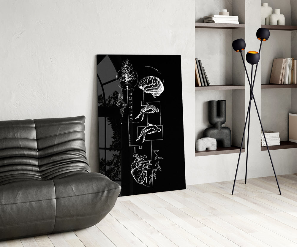 balance brain and heart line art glass wall art leaning beside a dark leather sofa