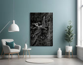 winged figure every fall to rise glass wall art styled above an armchair in a reading corner