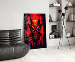 a horned demon face burning out of red flame glass wall art leaning beside a dark leather sofa