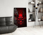a red horned skull with a third eye glass wall art leaning beside a dark leather sofa