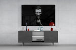 a grinning pale figure calling for silence glass wall art displayed above a console in a designer interior
