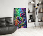a neon jungle flower goddess holding a skull glass wall art leaning beside a dark leather sofa