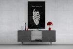 a skeleton hand gripping a roll of cash glass wall art displayed above a console in a designer interior