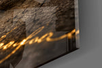 Close-up detail of the golden dust falling from the crumbling stone arches on the glass surface