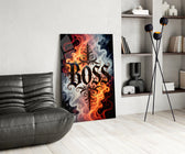 blackletter word in fire and smoke glass wall art leaning beside a dark leather sofa