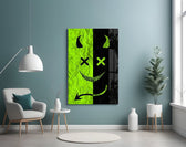 split neon green devil smiley glass wall art styled above an armchair in a reading corner