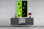 split neon green devil smiley glass wall art displayed above a console in a designer interior