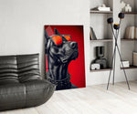 black guard dog on crimson red glass wall art leaning beside a dark leather sofa