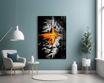orange lava rift and lone figure glass wall art styled above an armchair in a reading corner