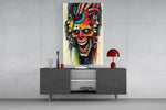 layered faces around a screaming skull glass wall art displayed above a console in a designer interior