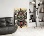 all seeing eye above a horned skull glass wall art leaning beside a dark leather sofa