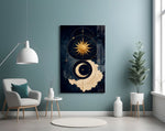 a gold sun and crescent moon on navy glass wall art styled above an armchair in a reading corner