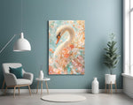 a white swan among peach and mint blossoms glass wall art styled above an armchair in a reading corner