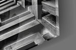 Close-up detail of the lit edges tracing each stacked beam on the glass surface