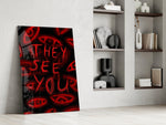 a red handwritten warning over watching eyes panel resting in a shelving niche in a modern interior