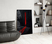 a cloaked figure at a red doorway glass wall art leaning beside a dark leather sofa