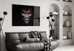 cracked gray grinning demon face glass wall art styled above an armchair in a reading corner
