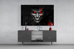 cracked gray grinning demon face glass wall art displayed above a console in a designer interior