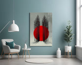 crimson sun behind bare poplars glass wall art styled above an armchair in a reading corner