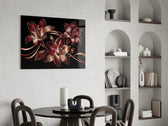 crimson and gold line-art lilies glass wall art leaning beside a dark leather sofa
